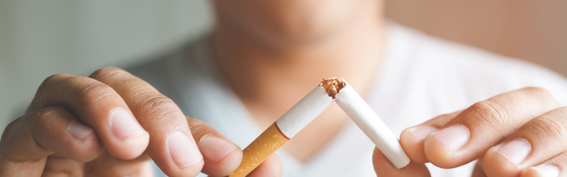 En mand der knækker en cigaret