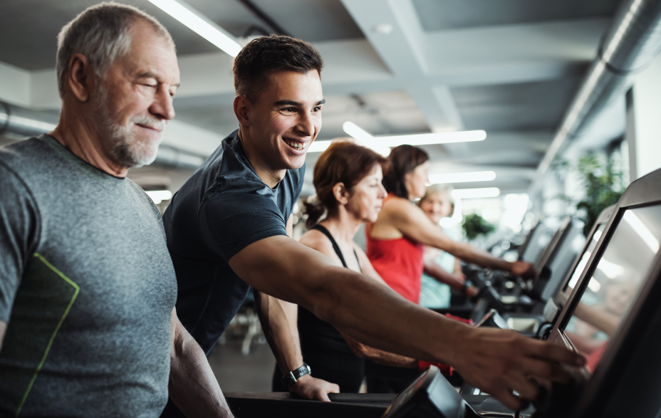 ung mand, hjælper ældre mand med løbebånd