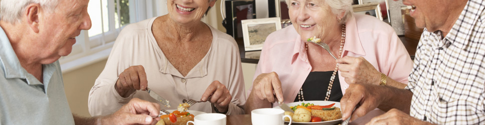 4 mennesker sidder og spiser frokost