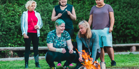 Beboere og pædagoger samles om bålet.