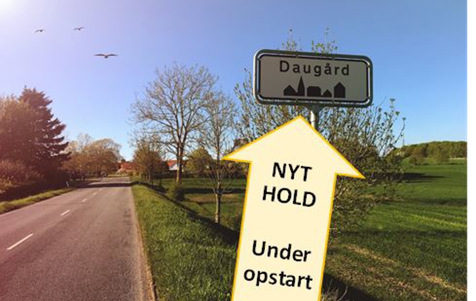 Pil peger på Daugård byskilt, hvori der står NYT HOLD under opstart i pilen