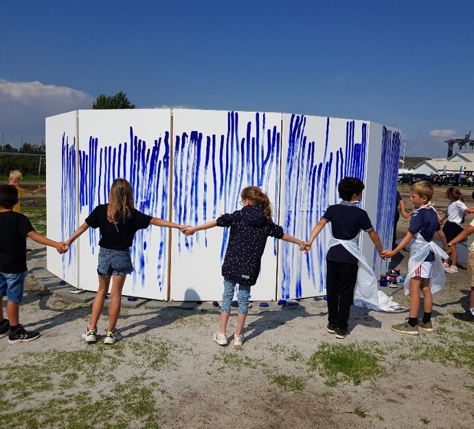 Børn i rundkreds omkring kunstværk