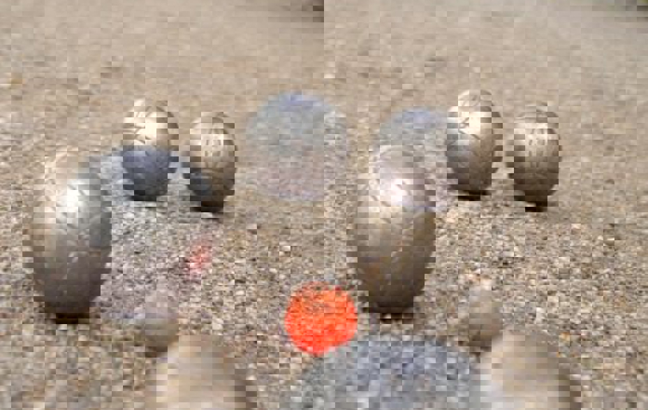 4 petanque kugler og en mand i baggrunden